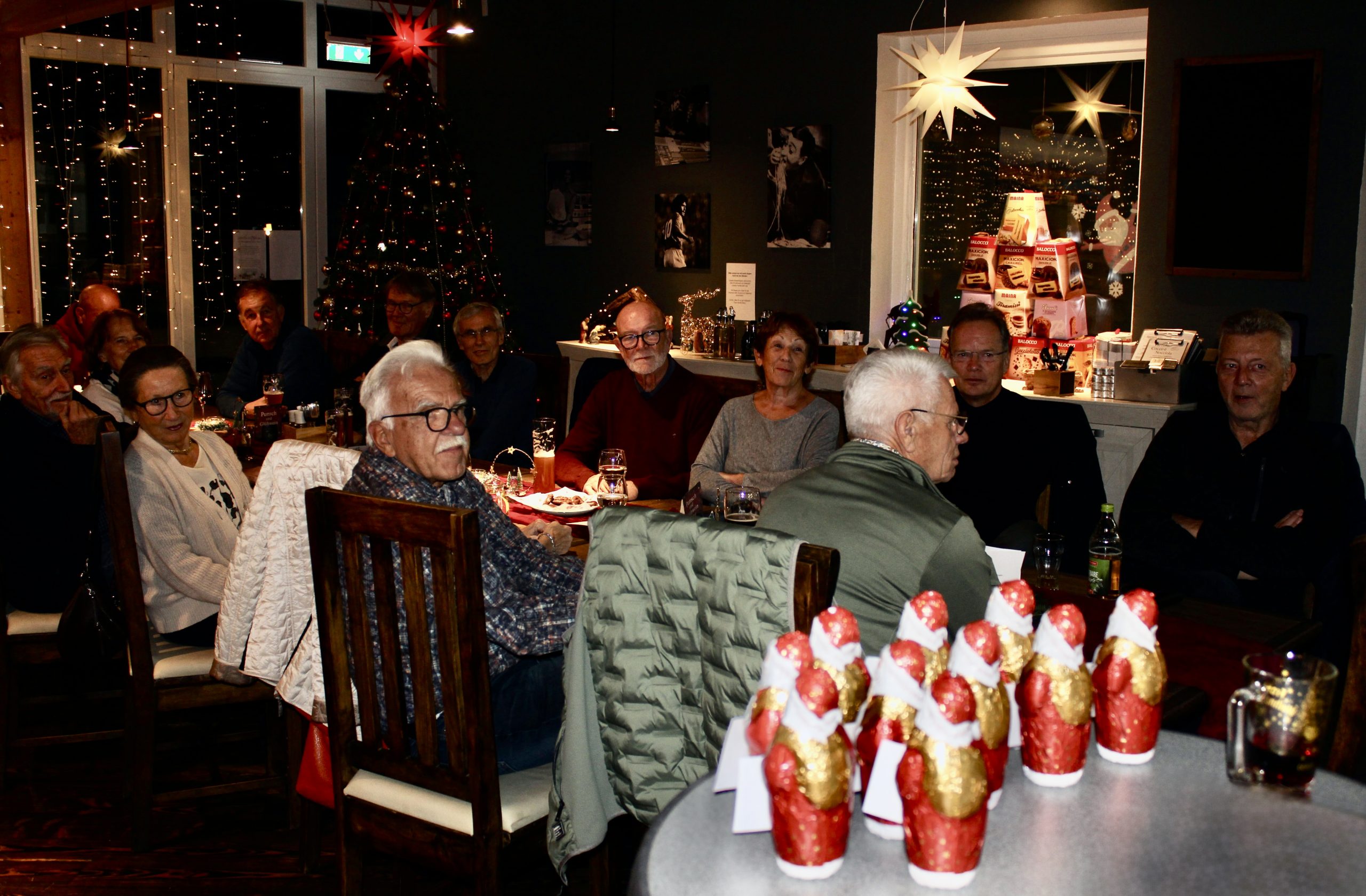 Das Bild zeigt (im Vordergrund) Schoko-Nikoläuse sowie zahlreiche Tennisfreundinnen und Tennisfreunde